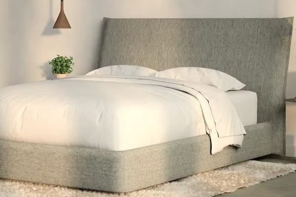 A fully made bed with a Haven Bed Frame and headboard. Corner view.